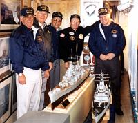 Photo taken at the U.S. Navy Cruisers Association display on board the USS Salem (CA-139), located at the United States Shipbuilding Museum, Quincy, Massachusetts. Standing in back of the newly acquired model of the USS Macon; Paul Sfreddo, President, USS Macon Veteran's Association; Harold Foley, past President and former Treasurer, Macon Association; Ed August, Treasurer, Cruiser Sailors Association; Bill Hennessey, President Massachusetts Chapter, Cruiser Sailors Association; and Bud Johnson, Treasurer, Macon Association.